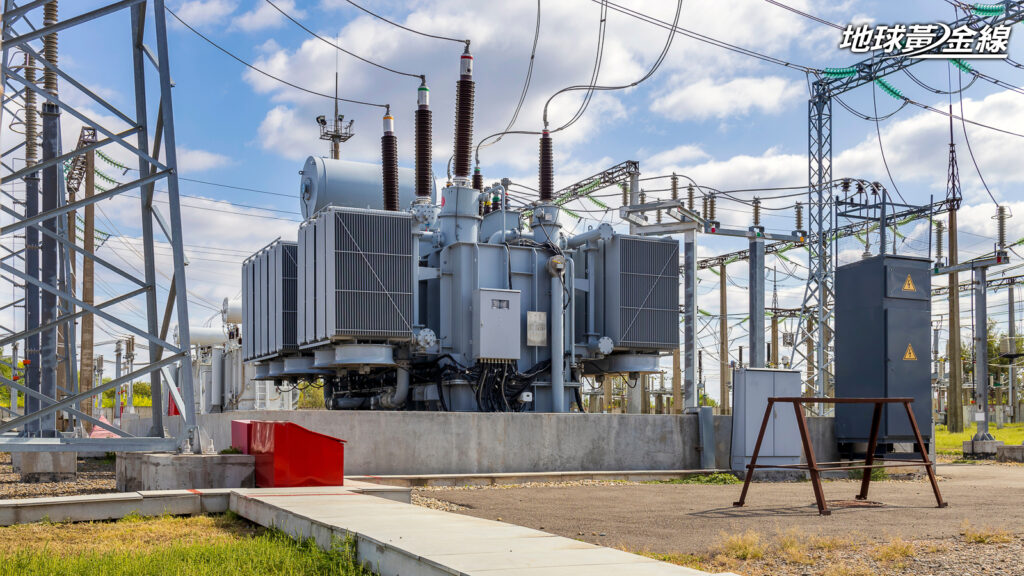 Three-phase high-voltage transformer of high electrical power at a substation against the blue sky.