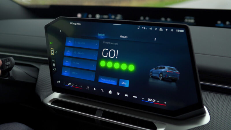 A BMW M in-car display showcases the M Drag Meter app with a customizable instrument cluster, gamified acceleration measurement, and an illustration of a BMW iX3, highlighting BMW's latest Operating System X features.